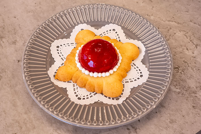 「ブローチケーキのアップ写真。本物の宝石のように輝くフランボワーズグラサージュ」